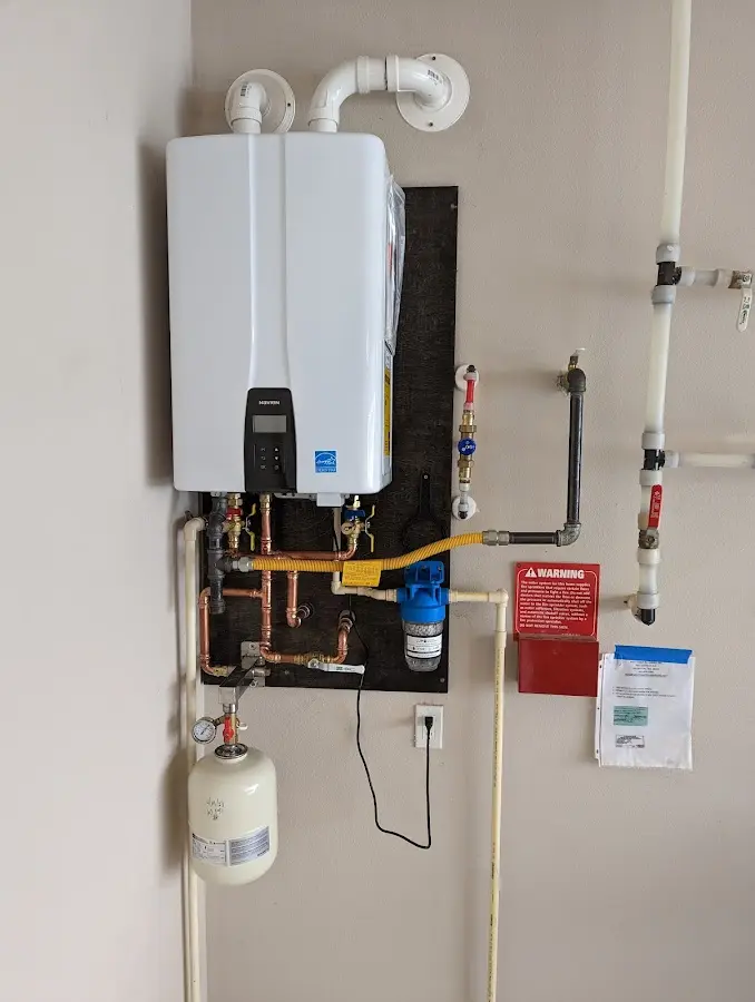 Professional plumber installing copper piping in a McCalla home